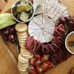Elegant charcuterie board featuring brie, salami, crackers, fruits, and honey for a perfect gourmet experience.